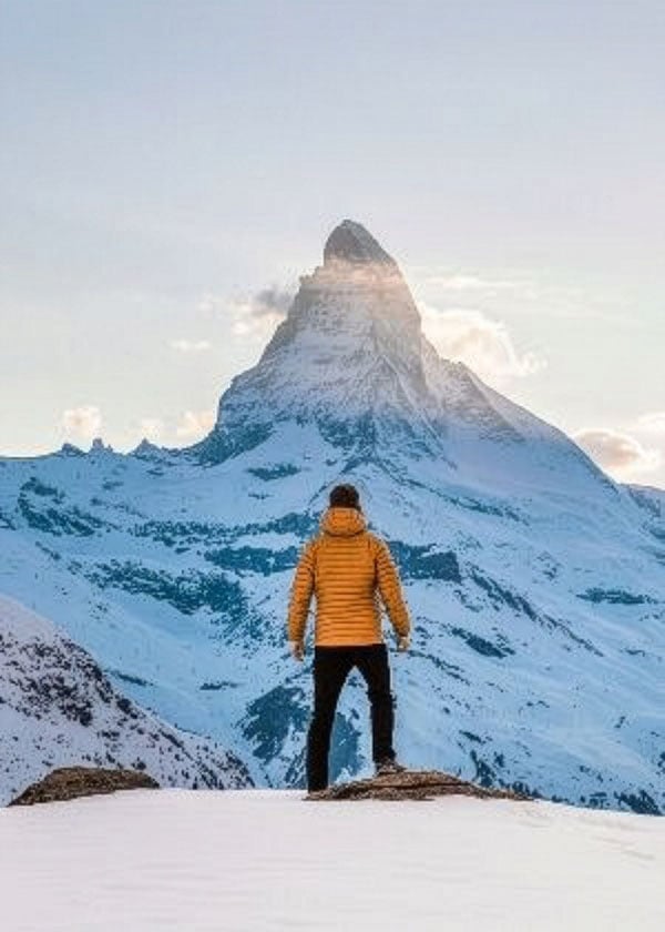 A man stands on top of a mountain